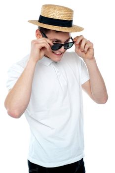 Man looking from behind sunglasses and smiling wearing hat