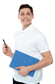 Smiling young man with notepad and pen against white background