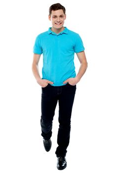 Handsome guy in walking pose. Studio shot over white background