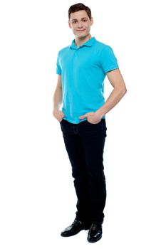 Full length portrait of casual young man posing with hands in pocket