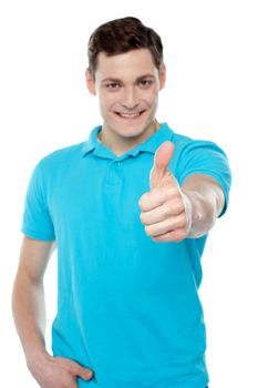 Handsome casual smiling guy showing thumbs up to camera isolated against white background