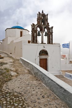 Old Greek church with belltower and greek flag