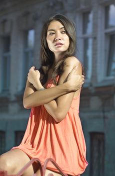 beautiful brunette in coral dress on the street