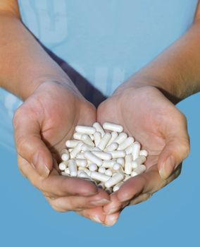 Many white pills a two hands of woman