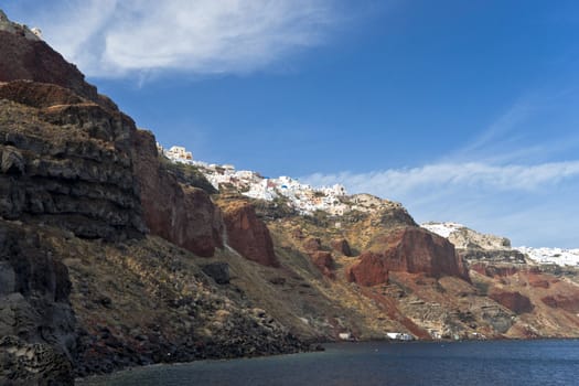 Ia houses view with volcanic rock of red and black colors below