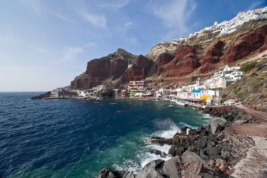 Ia houses view with volcanic rock of red and black colors and the port below