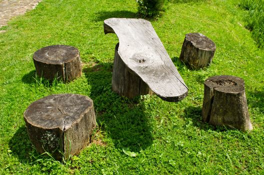 Table and chairs made of wood trunk stumps. Place for rest.