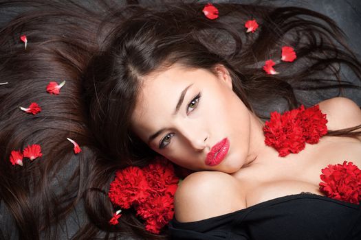 Pretty woman with long hair and red carnations