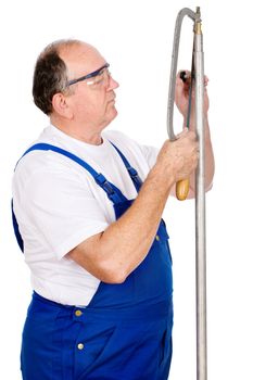 Middle age worker cutting screw on a metal tube, isolated on white background