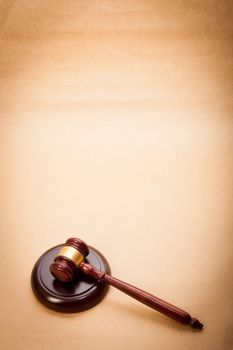 A wooden gavel and soundboard on a light brown background.