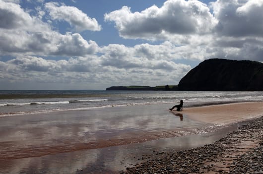 Person relaxing on the beach at Sidmouth