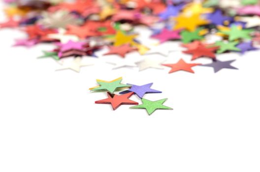 Christmas decoration of colored confetti stars against white background