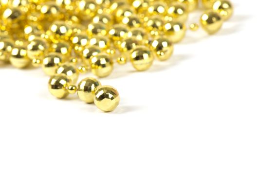 Background made of a brilliant celebratory beads of golden color over white