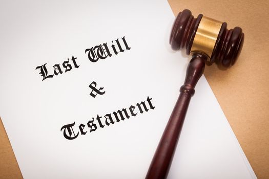 A gavel on top of a "Last Will and Testament" contract, with a antique-like background.