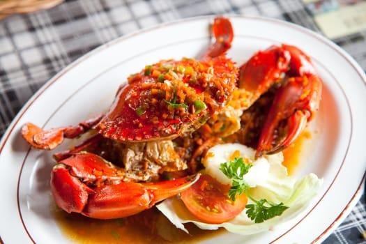 cooked crabs with spicy sauce on white plate (selective Focus)