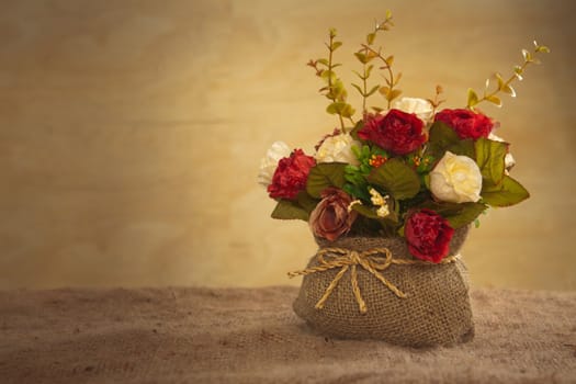 still life with rose flower on hessian background