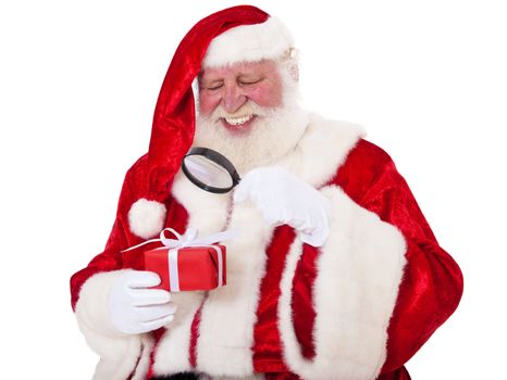 Santa Claus in authentic look checking little present with magnifier. All on white background.