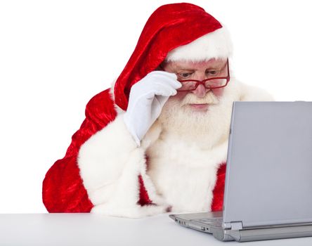 Santa Claus in authentic look using laptop. All on white background.