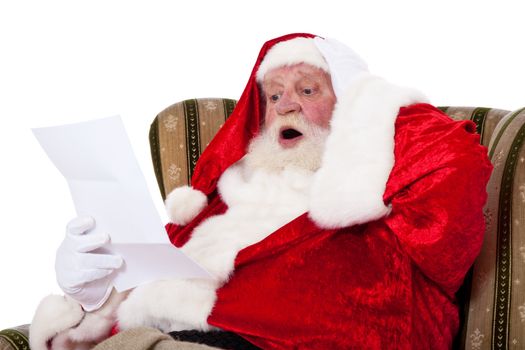 Santa Claus in authentic look reading wish list with surprised facial expression. All on white background.