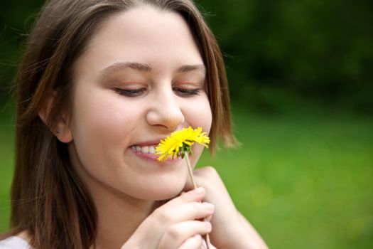 Attractive young woman with dandelion.