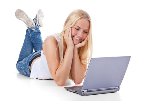 Attractive teenage girl lying on floor with laptop. All on white background.