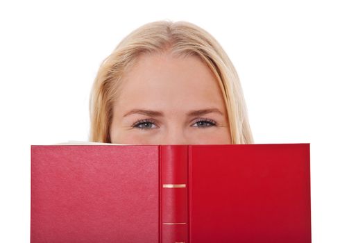 Attractive teenage girl hiding her pretty face behind book. All on white background.