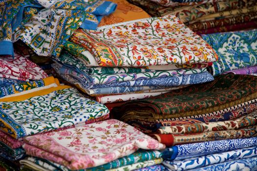 Traditional provencal market stall offering colorful textiles.