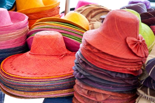 Stall offering colorful straw hats.