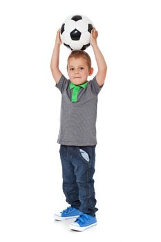Full length shot of a cute little boy playing with a soccer ball. All isolated on white background.