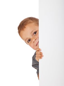 Cute little boy hiding behind a white wall. All isolated on white background.