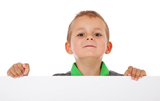 Cute little boy standing behind white wall. All isolated on white background.