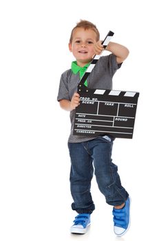 Full length shot of a cute little boy holding a clapperboard. All isolated on white background.