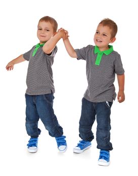 Full length shot of twin brothers having fun. All isolated on white background.