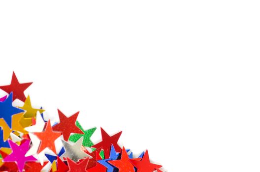 Christmas decoration of colored confetti stars against white bac
