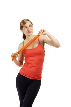 beautiful young fitness woman train with a orange ribbon on white background