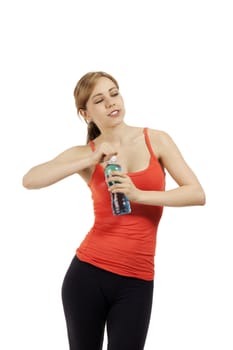 young cute fitness woman opening a bottle of water looking to side on white background