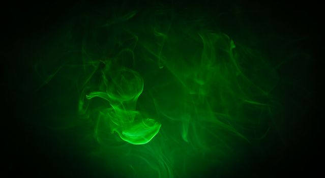 Green smoke in the dark on black background