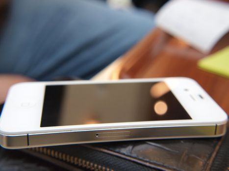 Closeup of a mobile phone, on top of wallet