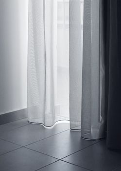 Soft light coming in apartment through thin white curtains