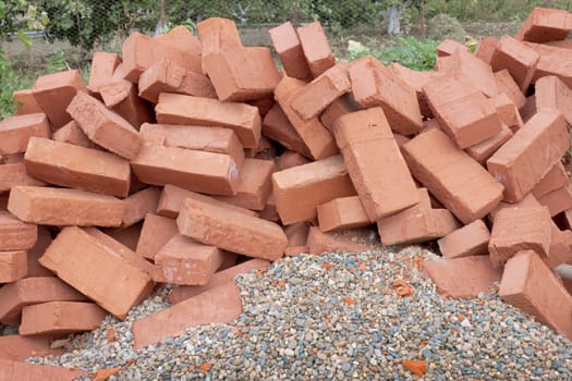 Lots red clay bricks lying on the gravel