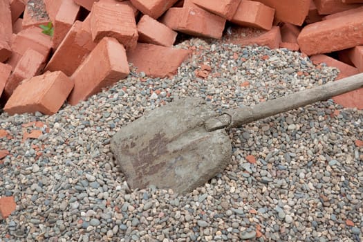 Lots red clay bricks lying on the gravel