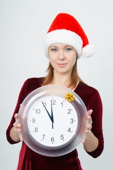 Christmas Eve. A young attractive girl with a clock