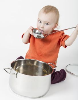 baby with big cooking pot isolated on neutral background