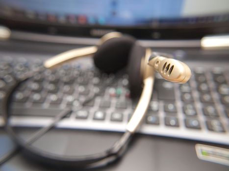 Closeup of microphone on headset, laying on a computer keyboard