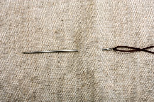 needle and golden thread on background fabrics