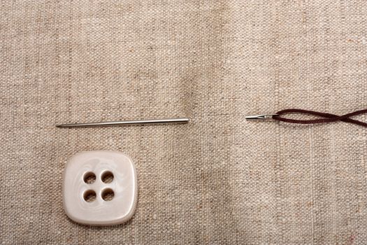 button needle and thread on background fabrics