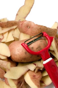 Potato cut in half with a potato peeler on white background