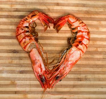 prepared shrimp forming a heart on striped wood texture