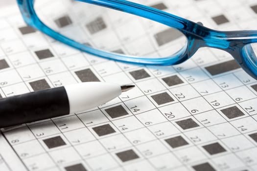 pencil spectacles on crossword puzzle background