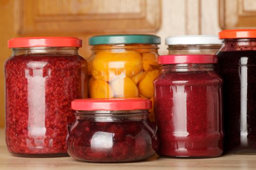 Sweet preserves as jams and compotes on table in kitchen